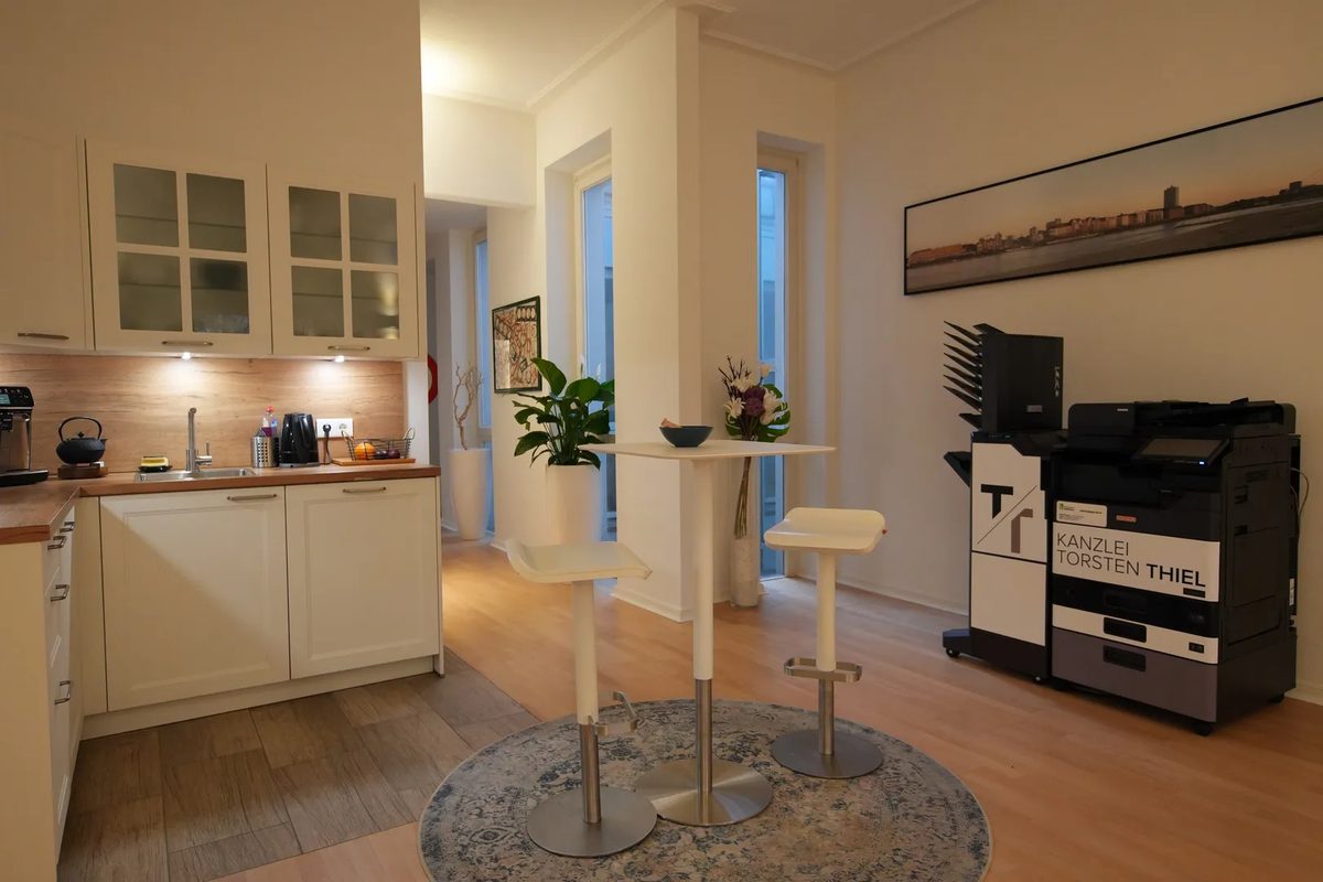 Heller Flur der Altbau-Etage mit Stehtisch