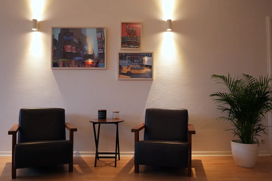 Wartebereich der Kanzlei mit Sesseln und Kunst an der Wand